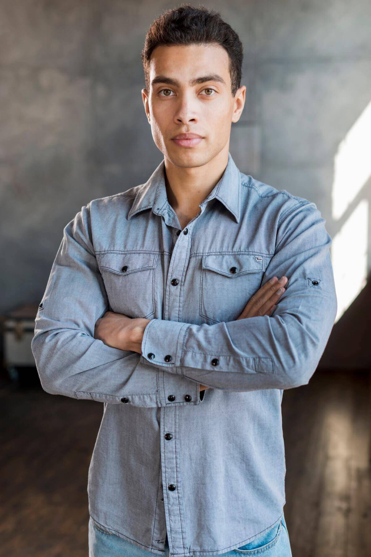 portrait-handsome-young-man-denim-shirt-with-his-arm-crossed-looking-camera